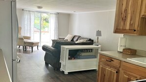 Een compacte leefruimte met een bank, een eettafel en een kitchenette.