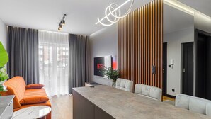 Een moderne woonkamer met een bank, een salontafel, een televisie en een houten accentmuur.