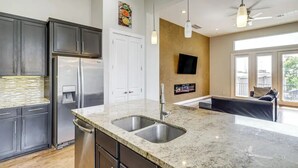A modern kitchen with granite countertops, stainless steel appliances, and a large window providing natural light. - Houston Home w/ Rooftop Patio - 3 Mi to Downtown!
 (Houston)