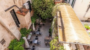 An outdoor seating area with tables and chairs, surrounded by greenery and a covered walkway. - Ca' Beatrice (Venice)