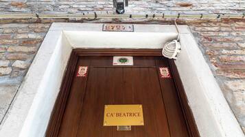 Eine Holztür mit einem Schild, auf dem 'CA' BEATRICE steht, und einem kleinen Wappen darüber.