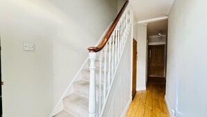 A staircase with white balusters and wooden handrails leading to a landing. - Hyperion in Newmarket (Newmarket)