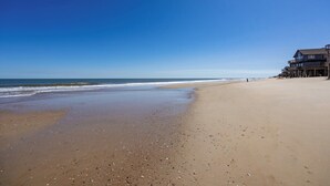 A beach with a wooden pier extending into the ocean, a clear sky, and a sandy shore. - Gloria - Offshore Beach Club (Buxton)