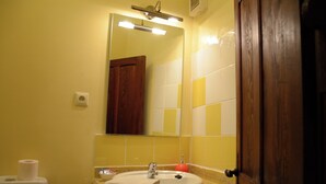 Un baño con lavabo, espejo y retrete.