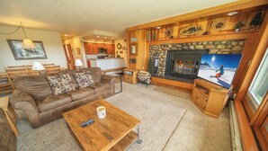 A cozy living room with a fireplace, a television, and a coffee table. - Family Fav, Indoor Pool/Hot Tubs, Shuttle (Keystone)