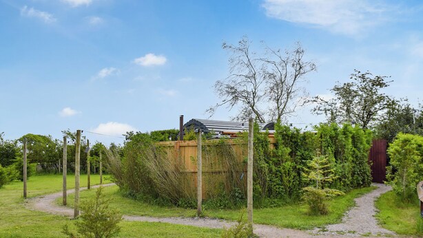 A garden with a wooden fence, a path, and a house in the background. - Laurel Pod - UK47203 (Lathom, near Southport)