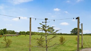 A rural landscape with a clear sky, a wooden fence, and a small tree in the foreground. - Laurel Pod - UK47203 (Lathom, near Southport)