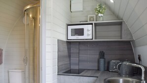 A compact kitchen with a microwave, sink, and a small countertop area. - Laurel Pod - UK47203 (Lathom, near Southport)