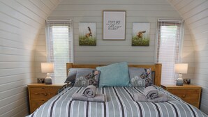 A bedroom with a bed, two nightstands, a wooden headboard, and two wall-mounted pictures. - Laurel Pod - UK47203 (Lathom, near Southport)