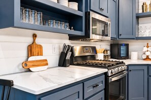 A modern kitchen with a built-in oven, microwave, and gas stove.