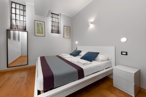 A modern bedroom with a bed, bedside table, and wall-mounted light. - Casa da Suite Cadorna (Milan)