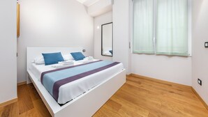 A modern bedroom with a large bed, a mirror, and a window with curtains. - Casa da Suite Cadorna (Milan)