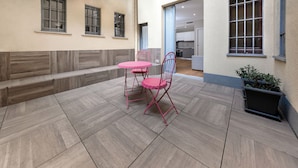 A patio area with a table and chairs, a potted plant, and a view of the interior. - Casa da Suite Cadorna (Milan)