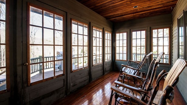 A room with large windows, wooden floors, and several rocking chairs. - Bearities - 2 homes, sleeps 28, hot tubs, grills! (Killington)