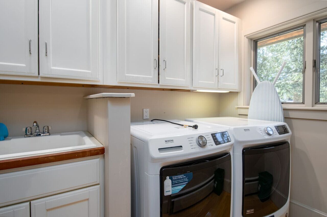 A laundry room with a washing machine, dryer, and a sink.