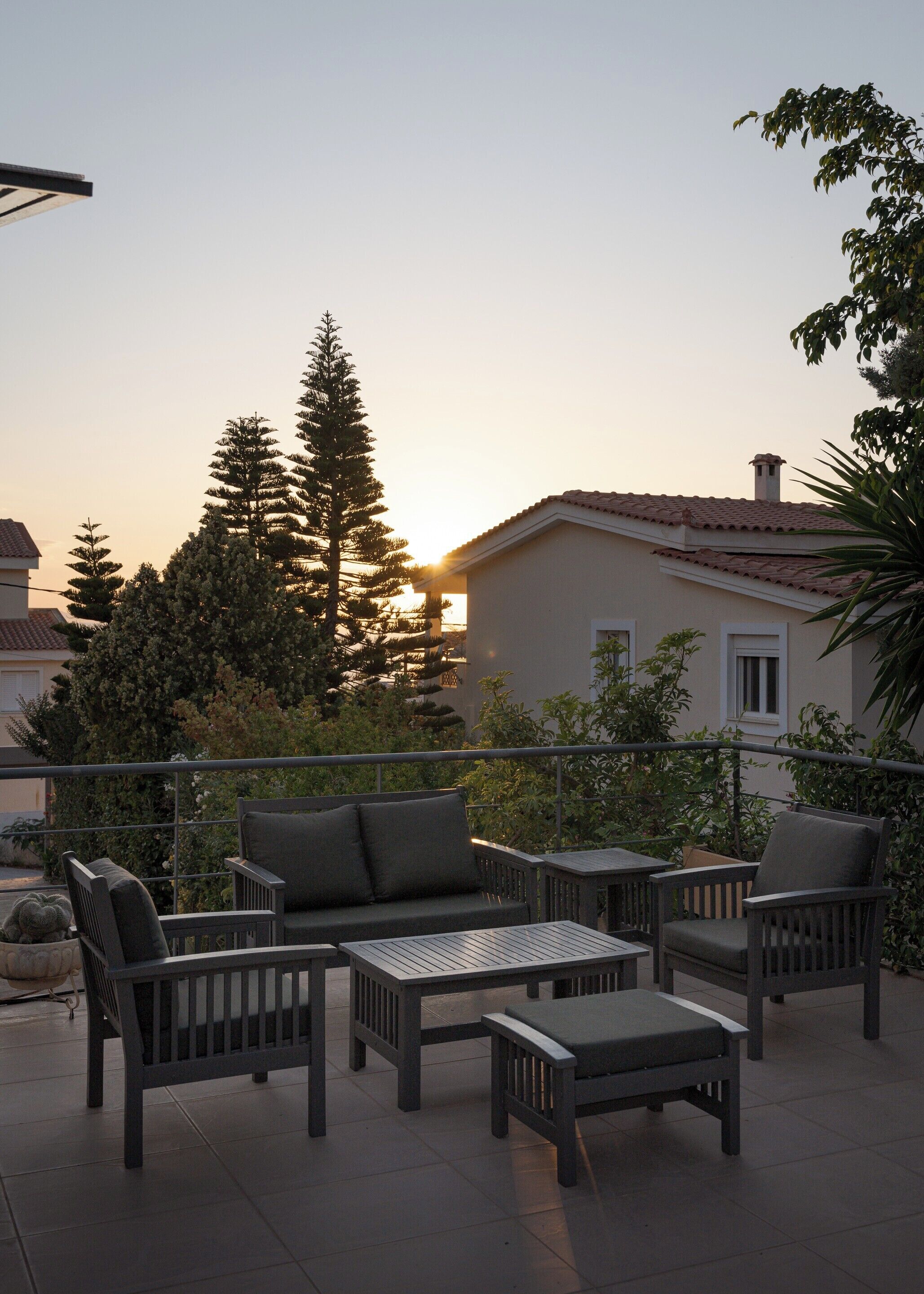 An outdoor patio area with a sofa, chairs, and a table.