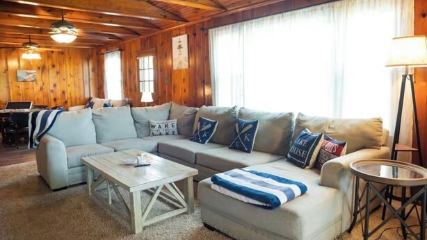 A cozy living room with a sectional sofa, a coffee table, and a lamp. - Cozy lake retreat in Sand Point! Game room with deck and views of Lake Texoma. (Mead)