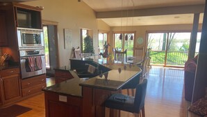 Una cocina espaciosa con una isla central, armarios de madera y horno empotrado.