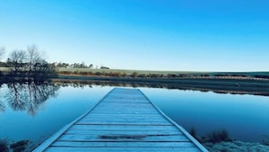 A wooden pier extending into calm water with a clear blue sky above. - Cedar Lodge - Idyllically situated Lakeside & private hot tub fishing riding (Northumberland)