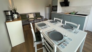 A compact kitchen with a dining area, a sofa, and a coffee maker. - Proche Gare, Commerce et Plage Avenue Louis Lajarrige (La Baule-Escoublac)
