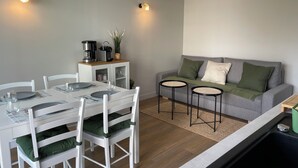 A compact living space with a dining area, kitchenette, and seating area. - Proche Gare, Commerce et Plage Avenue Louis Lajarrige (La Baule-Escoublac)