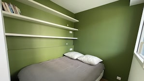 A bedroom with a bed, green walls, white shelves, and a window. - Proche Gare, Commerce et Plage Avenue Louis Lajarrige (La Baule-Escoublac)