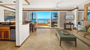 A spacious living area with a view of the ocean, a dining area, and a kitchen with a view.