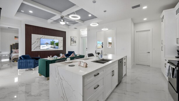 A modern kitchen with a marble countertop, built-in appliances, and a large island. - Modern Vacation Home Fully Fences Near Airport (Lehigh Acres)