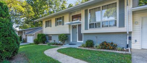A two-story house with a front entrance, a garage, and a well-maintained lawn.