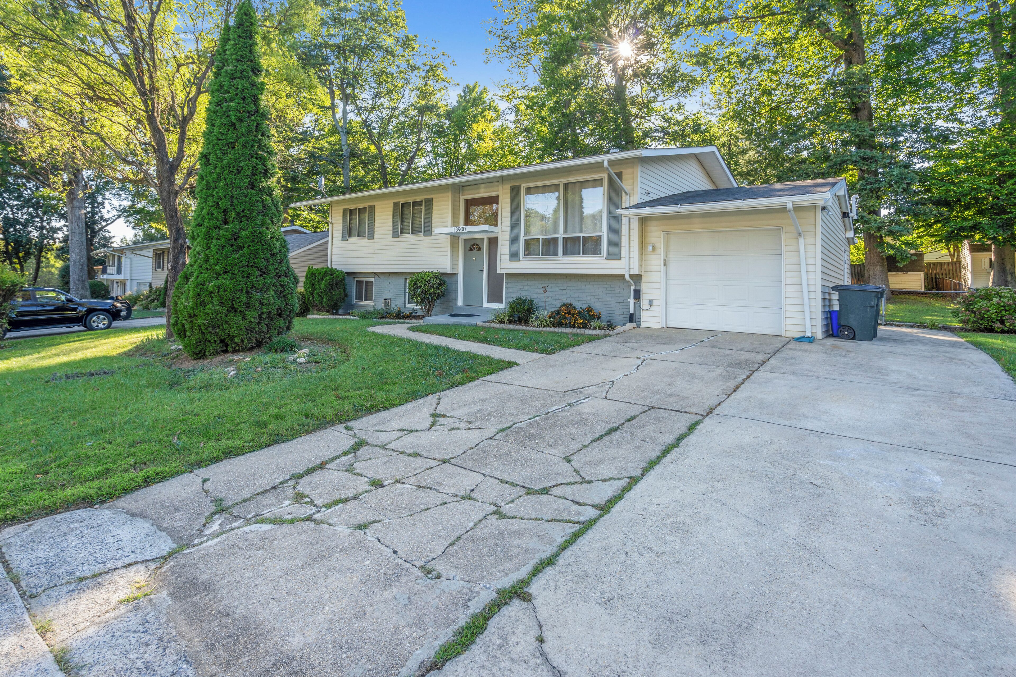 A two-story house with a garage, a driveway, and a well-maintained lawn.