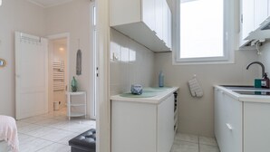 A compact kitchen with white cabinets, a small countertop, and a window above the sink. - Arca Day - Appt 4p à Arcachon proche dune du pilat (Arcachon)