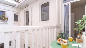A balcony with a table set for breakfast, including pastries and yellow cups, and a potted plant. - Arca Day - Appt 4p à Arcachon proche dune du pilat (Arcachon)