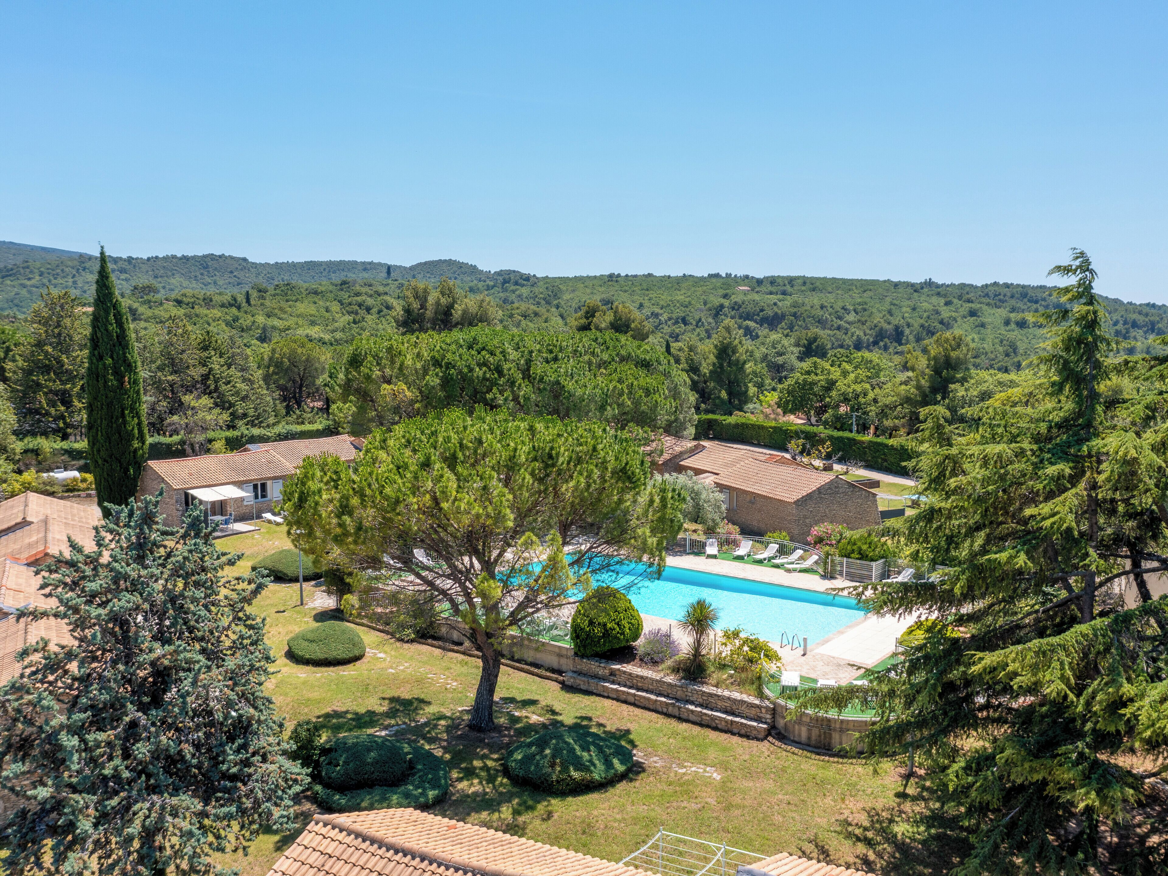 A pool area with a clear view of the surrounding landscape, including trees and distant hills.