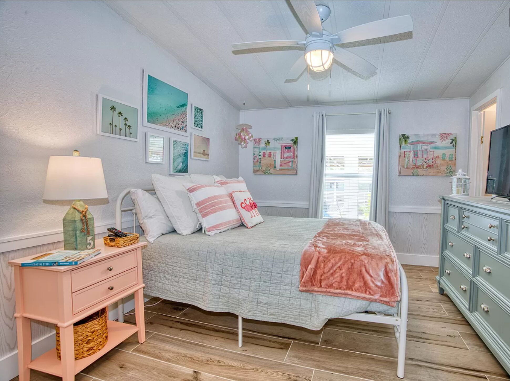 A bedroom with a bed, a nightstand, a dresser, and a ceiling fan.