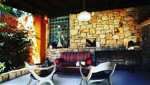A stone wall interior with a fireplace, two chairs, and a hanging light fixture. - Villa Lapis Vis - Treat yourself with the vacation you deserve! (Rukavac)