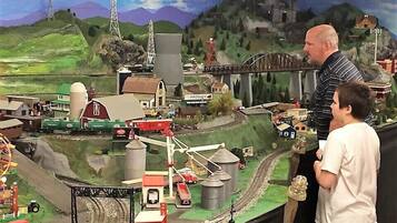 A model train setup with a bridge, buildings, and a landscape.