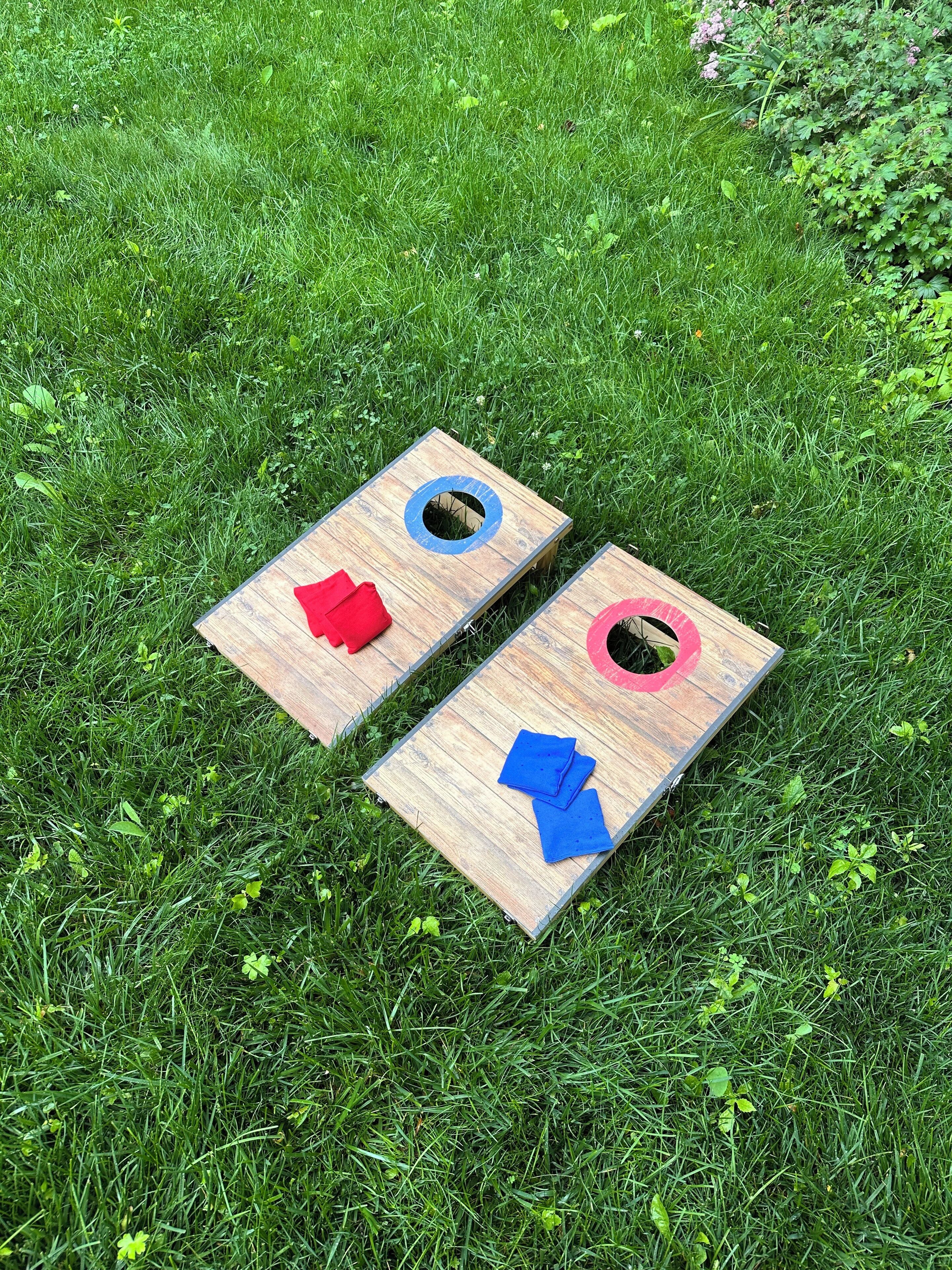 Two wooden boards with holes, placed on grass.
