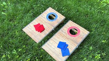 Two wooden boards with holes, placed on grass.