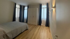 Quarto com cama, guarda-roupa e porta com luminária.