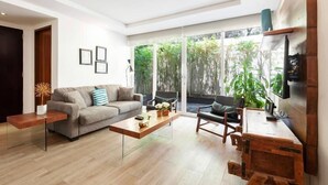 Una sala de estar moderna con un sofá, una mesa de centro y un mueble para televisor.