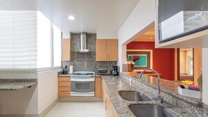 Una cocina moderna con encimeras de granito, electrodomésticos de acero inoxidable y armarios de madera.