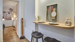 A modern kitchen with a wooden countertop, a hanging light fixture, and a decorative mirror. - Charming Apartment - Eiffel Tower/Trocadero (Paris)
