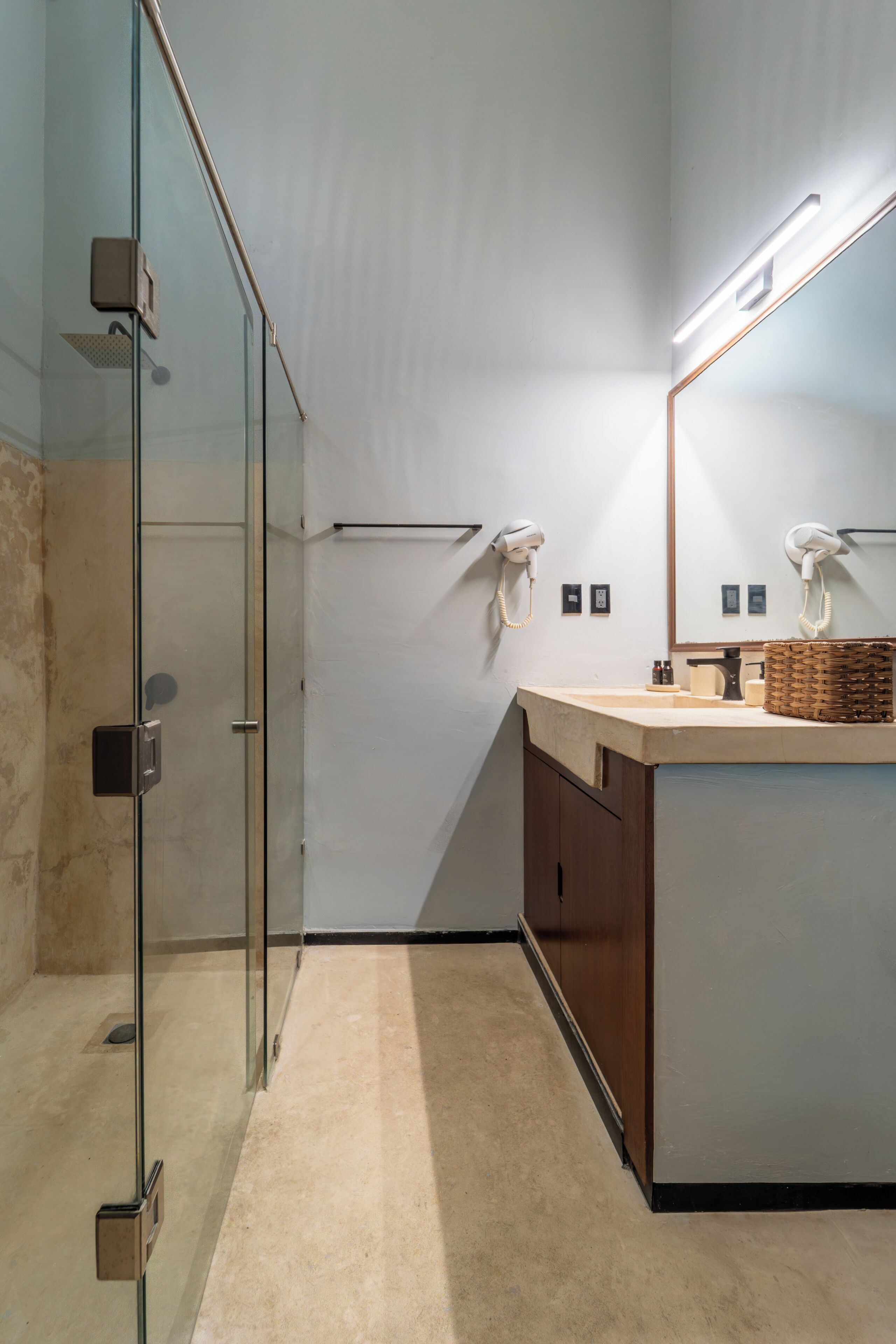 A modern bathroom with a glass shower enclosure, a vanity with a mirror, and a towel rack.