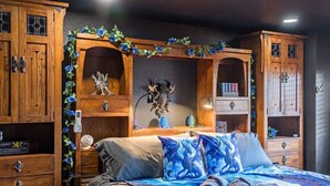 Une chambre à coucher avec un lit, des armoires en bois et des objets de décoration.