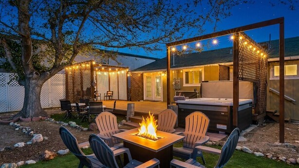 Une terrasse extérieure dotée d’un foyer, de sièges et d’un jacuzzi.