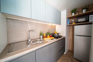 Een koelkast, een microgolfoven, een kookplaat, een kinderstoel