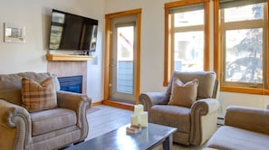 Relax in this stylish living room with a flat-screen TV, comfortable sofa, and armchair.