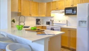 Enjoy cooking in this well-equipped kitchen with a microwave, stove, and sink.