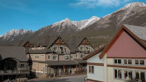 Ein Hotel mit Blick auf die Berge, mit einem markanten Eingangsbereich und mehreren Balkonen.