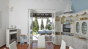 Un'ampia zona giorno con una grande finestra, un caminetto e un tavolo da pranzo.